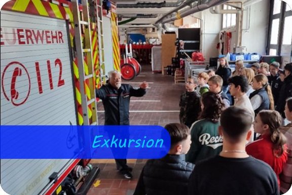 Auf der linken Seite lehnt ein Feuerwehrmann in Uniform am Heck eines Löschzuges und hebt erklärend die Hand. Ihm gegenüber stehen mehrere Jugendliche, die ihm zuhören. Überschrift: Exkursion