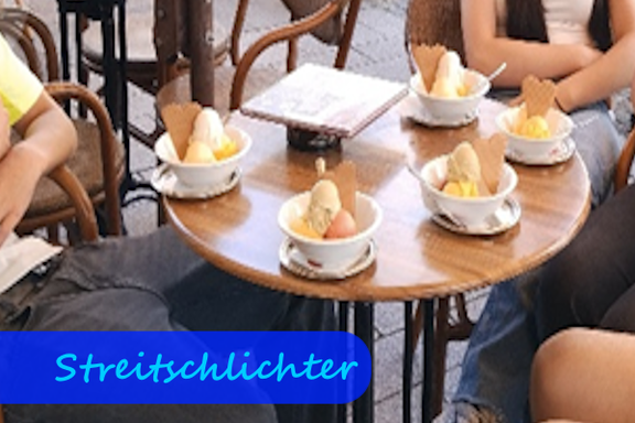 Auf einem Tisch sind fünf gefüllte Eisbecher zu sehen.