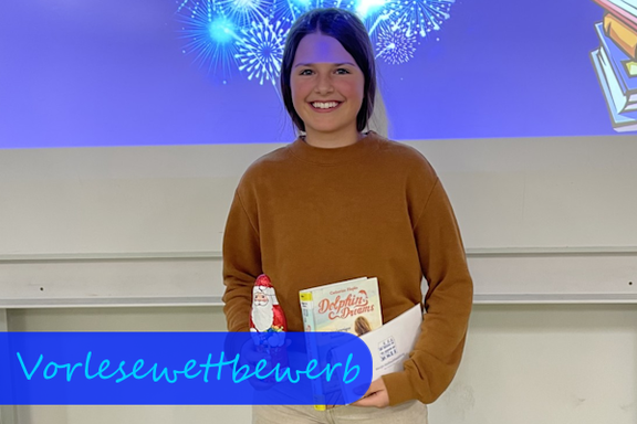 Schulsiegerin des Vorlesewettbewerbs 2024 Vor einem Hintergrund, der Feuerwerk zeigt, hält ein Mädchen lächelnd einen Schokonikolaus, ein Buch und einen Briefumschlag in der Hand.