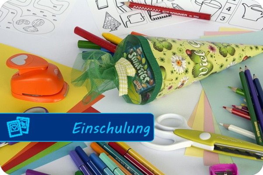 Auf einem Schreibtisch liegen Schulsachen wie Schere und Stifte und eine kleine Zuckertüte.