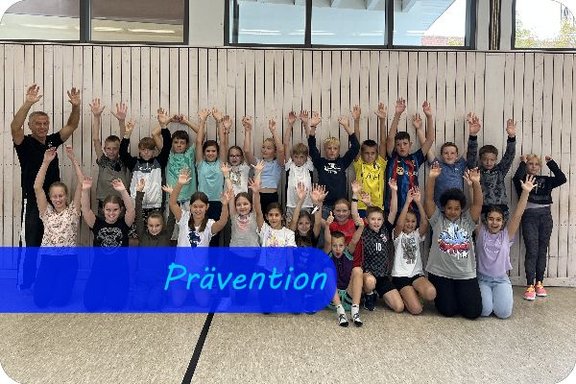 In drei Reihen stehen Kinder nebeneinander und heben alle gleichzeitig die Arme hoch. Am linken Rand steht ein erwachsender Trainer. Als Überschrift steht "Prävention".