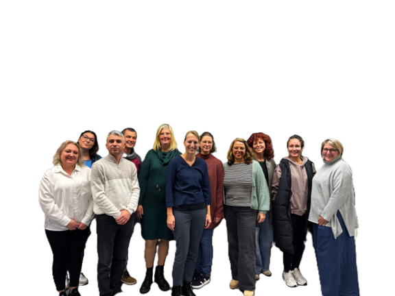 Mehrere Frauen und Männer haben sich für ein Gruppenfoto zusammengestellt und lächeln in die Kamera.