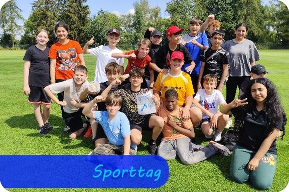 Auf einer Wiese stehen und knien Kinder die Jubelposen zur Kamera zeigen.