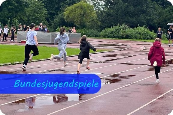 Sprint der Fünftlässlerinnen bei den Bundesjugendspielen Auf einer nassen Tartanbahn sprinten vier Mädchen vom Fotografen weg in Richtung Ziel.