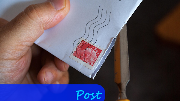 Ein Briefumschlag wird in der Hand gehalten und geöffnet.
